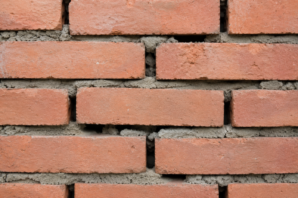 Incorrect bricklaying technique showing gaps in mortar joints